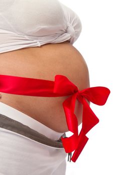 Pregnant woman with red ribbon on belly isolated on white