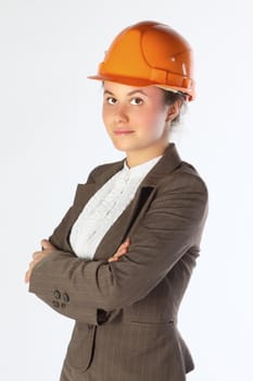 The young and beautiful girl in a business suit and a building helmet