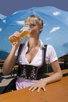 Young woman in traditional costume in the beer garden