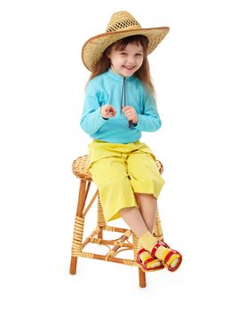 The little girl in a straw hat sitting on an old-fashioned wooden chair