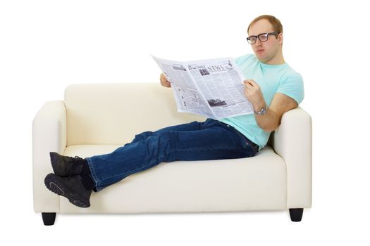 Person reading a newspaper lying on the couch at home