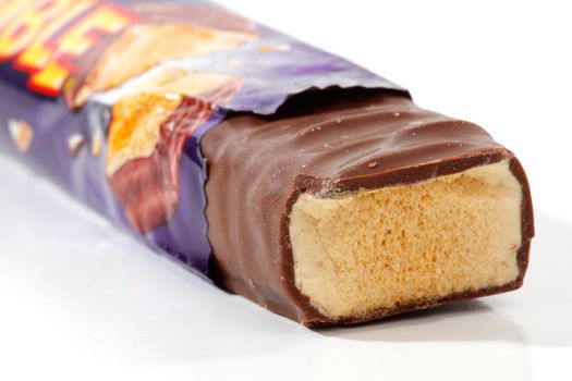 A Violet Crumble chocolate bar snack 50g, 990kj,  shown in packaging closeup.  White background.  Editorial use only.