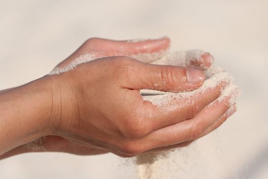 Sand running through hands n beach