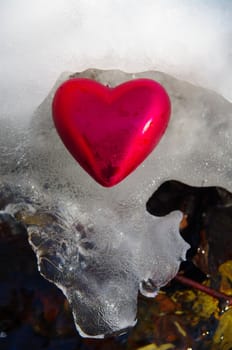 a red  heart on a real snowy icy surface