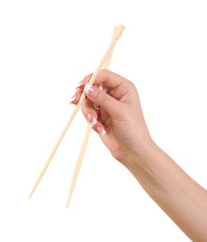 Female hand holding Chinese chopsticks against white background.