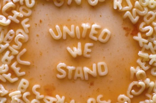 united we stand text made of food letters, tomato sauce with little parts