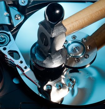 Magnetic disc inside a computer hd unit showing damage to the mirror surface of the magnetic discs and read write head from a hammer