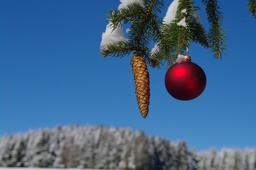 red bauble christmas ball ornament outside in a snowy winter scene