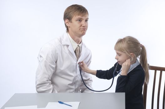 The doctor in a white dressing gown and the little girl at it on reception