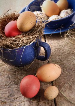 Colored easter eggs in blue enamel cup with straw