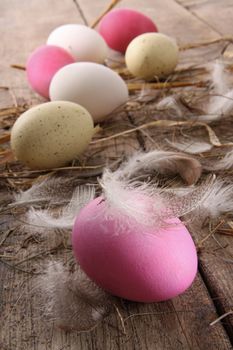 Colorful easter eggs with feathers on old wooden table