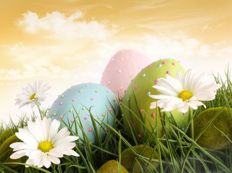 Closeup of decorated easter eggs in the grass with daisies