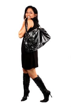 A happy Indian woman with her handbag out for shopping, isolated on white studio background.