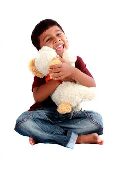 A cute Indian boy with a soft toy dog, on white studio background.