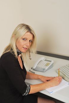 Secretary waiting to take notes at keyboard with phone