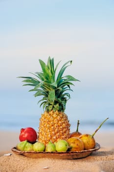 Pineapple and tropical fruit on the beach