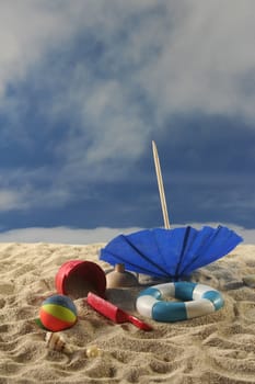 Sun Umbrella with toys, water polo and swimming ring at the beach