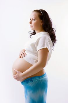 Young pregnant woman in clothes. Studio photography