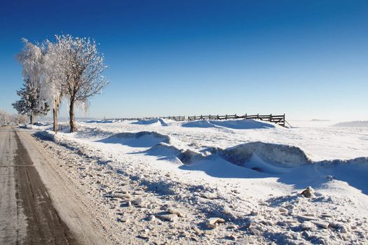 Winter road on a sunny frosty day with blue sky