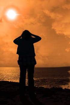 a lone woman looking sadly over the cliffs edge in county clare ireland