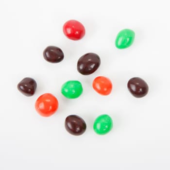 candy. Nuts in multicolored chocolate icing on a light background