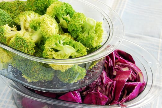 fresh green broccoli and magenta cabbage in steamer utensils