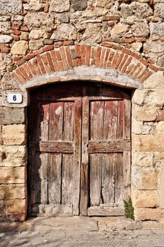 Old wooden door in an old brick wall