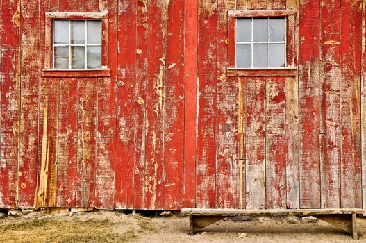 Red old barn with two windows and lonely bench, no sky and no horizon