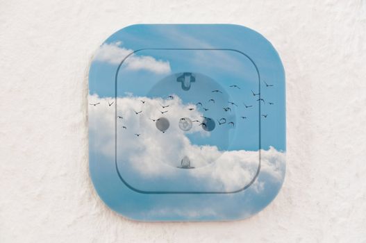 Conceptual: Flock of Birds in the Sky over power outlet on ingrain wallpaper. File contains clipping path.