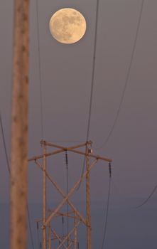 Power Line and Full Moon Saskatchewan Canada