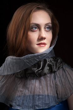Romantic portrait of a redhead beautyful girl in studio over black