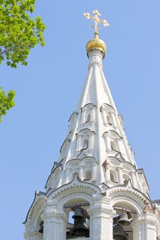 The bell tower of  orthodox Church against  blue sky, Russia.