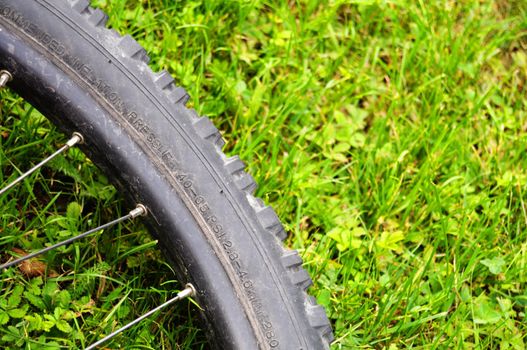 mountain bike offroad tire in green grass showing sport in nature concept