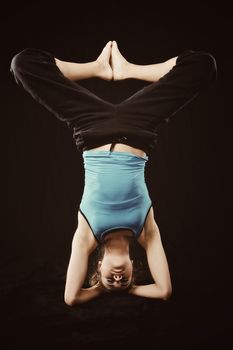 Young woman in tracksuit do yoga poses on head