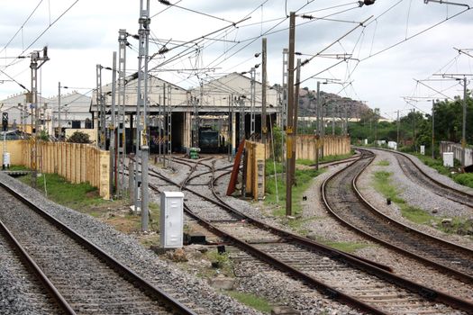 Railway tracks leading to a hangar with trains.