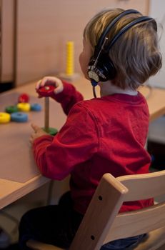 Small child (3 years old) taking a hearing test. A brick is placed on the stick every time she hears a sound. 