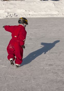 Small child (4 years old) ice skating, trying to keep the balance