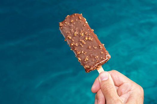 popsicle against a swimming pool on a hot day