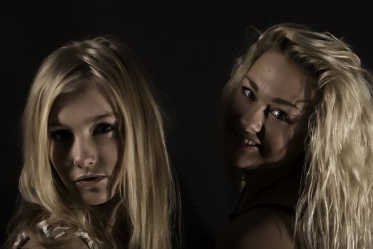  two young seductive blondes isolated on black