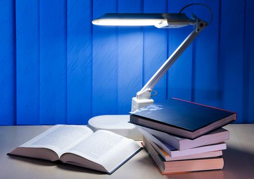 open book and pile books is on desk