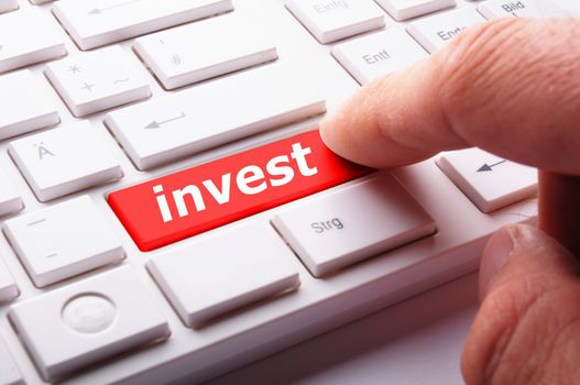 invest or investment key or button in red showing business success