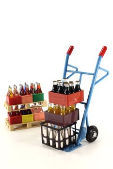 sack truck with cola, lemonade, milk and beverages stacked on euro pallets in the background