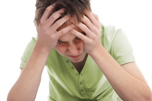 A teenager with head in hands wincing from pain of migraine, stress, anguish or depression.  White background.