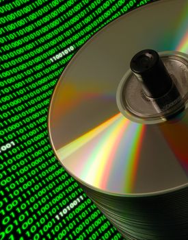 Close-up of a stack of CD/DVD disks on a Dutch angle, with a curved field of binary code