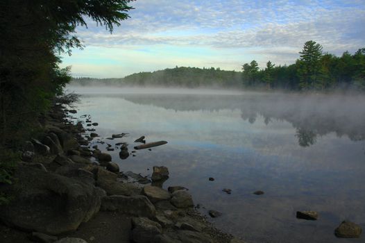 Early morning view of the mist rising from a lake in the wilderness