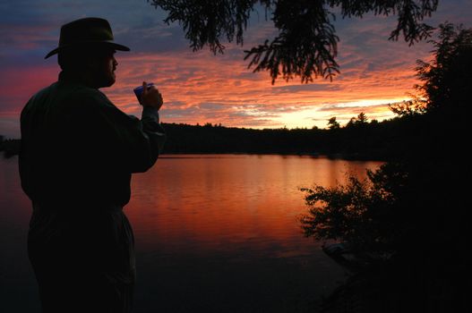 Camper watching sunset over lake