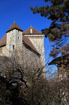 Old castle in Annecy, France, behind winter trees