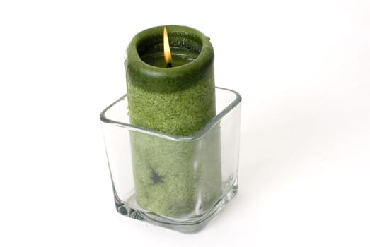 A green candle on a white background.