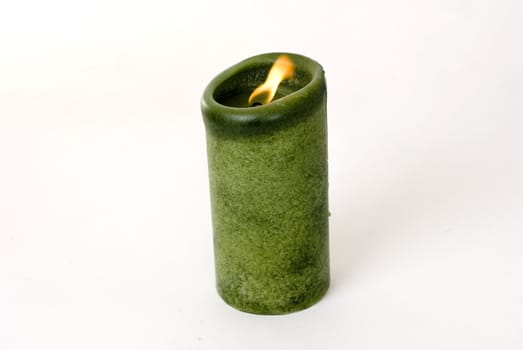A green candle on a white background.