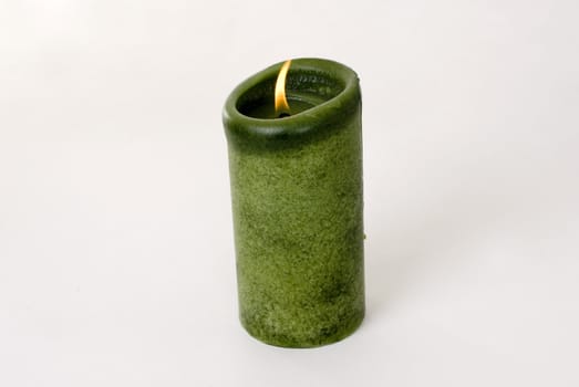 A green candle on a white background.